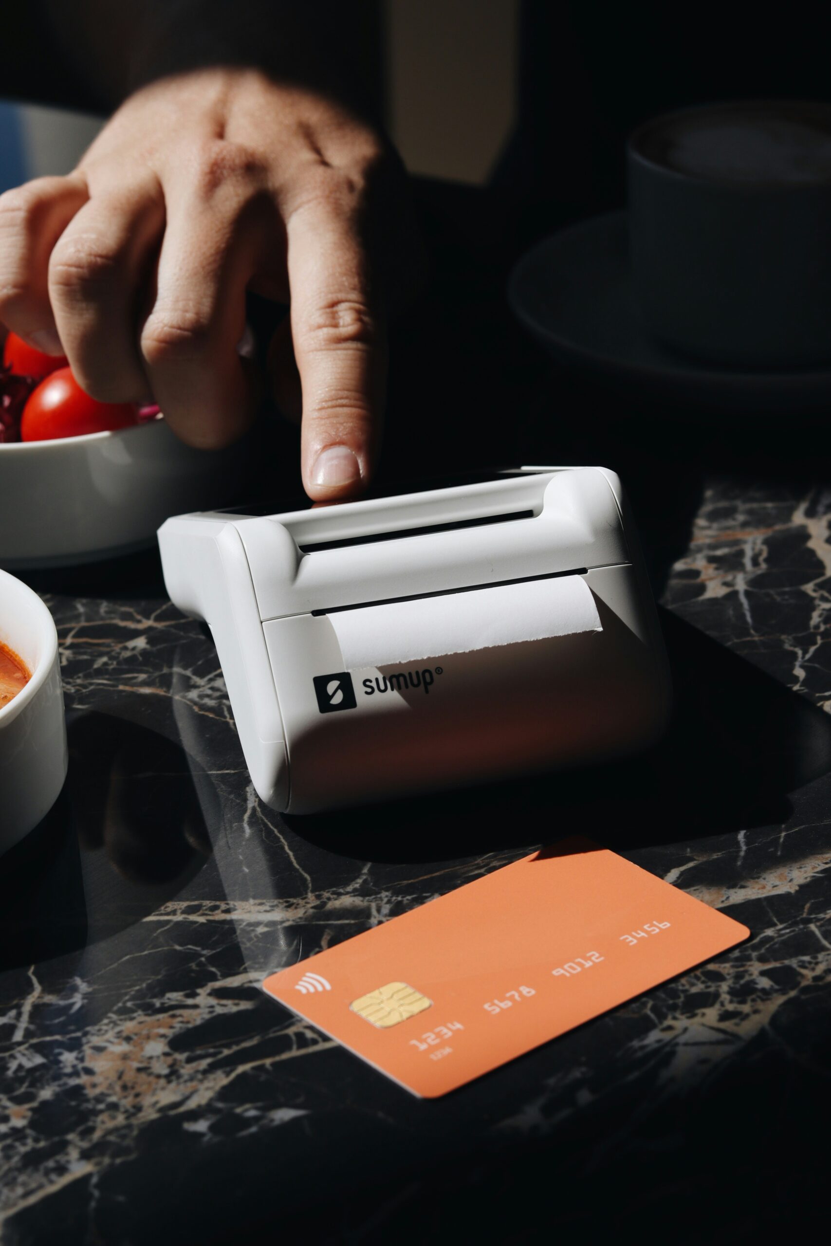 A person using a machine to cut tomatoes